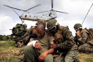 Corpsmen shield a simulated casualty from the rotor wash of a CH-46E Sea Knight helicopter 